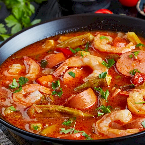 A hearty shrimp stew with sausage, tomatoes, peppers, potatoes, and herbs in a rich, tomatoy broth. Top it at 140 characters, always ending the sentence.