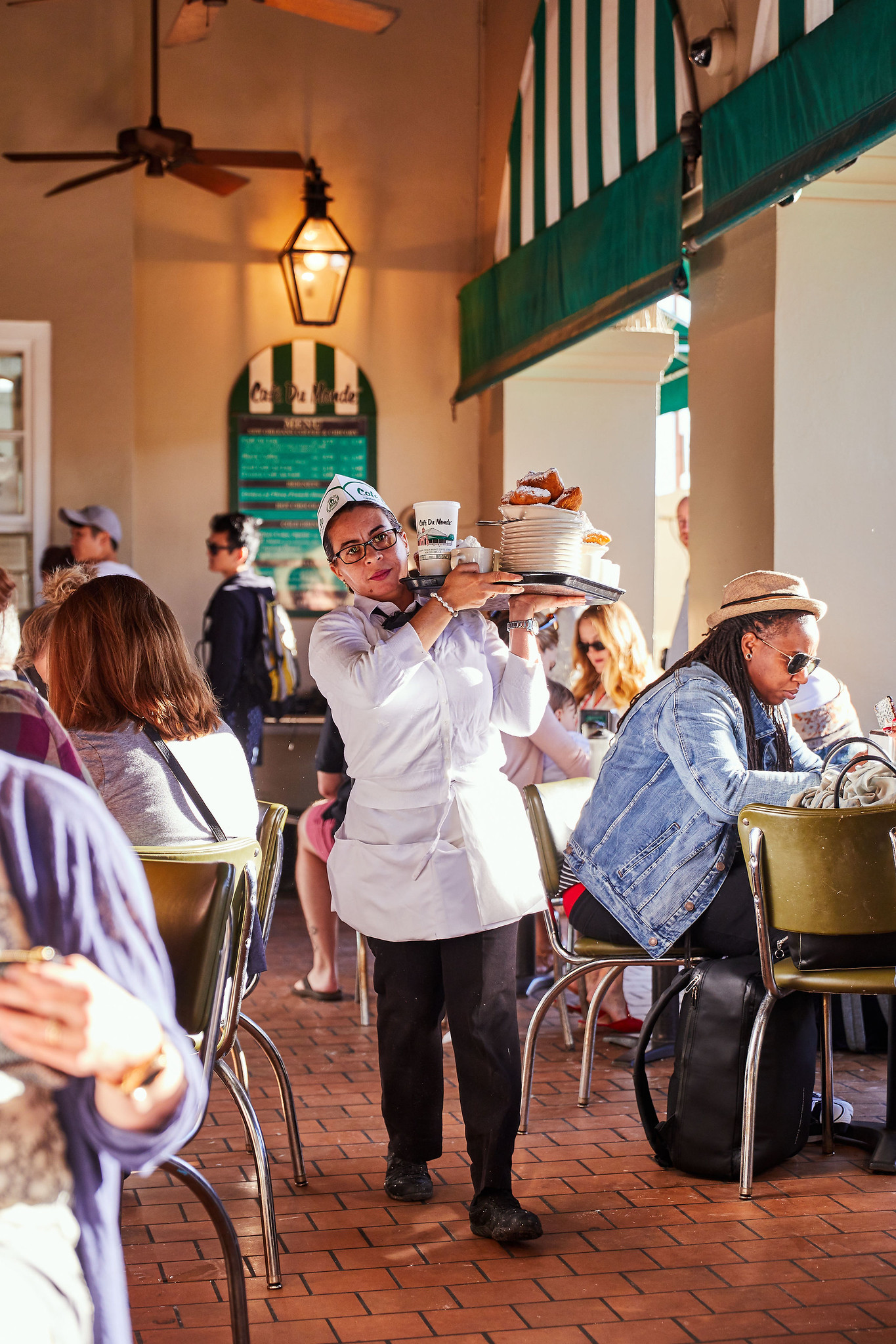 A waitress carrying a tray of food in a busy restaurant
