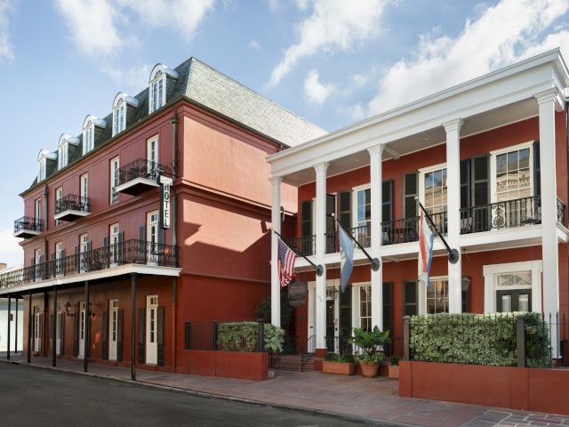 A red building with white columns and balconies